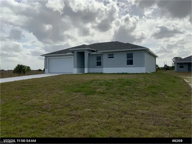 Single story home with a front yard, driveway, and an attached garage