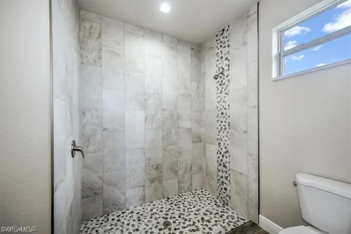 Full bathroom featuring a tile shower and recessed lighting