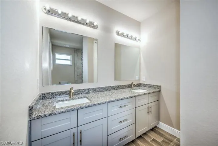 Bathroom with double vanity and light wood-style floors