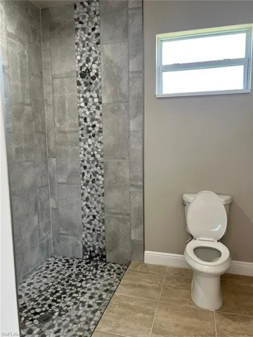 Bathroom with a stall shower and tile patterned flooring