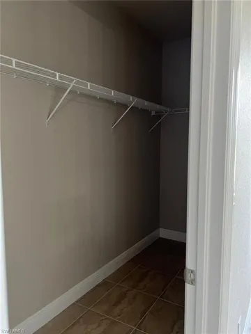 Walk in closet with light tile patterned floors