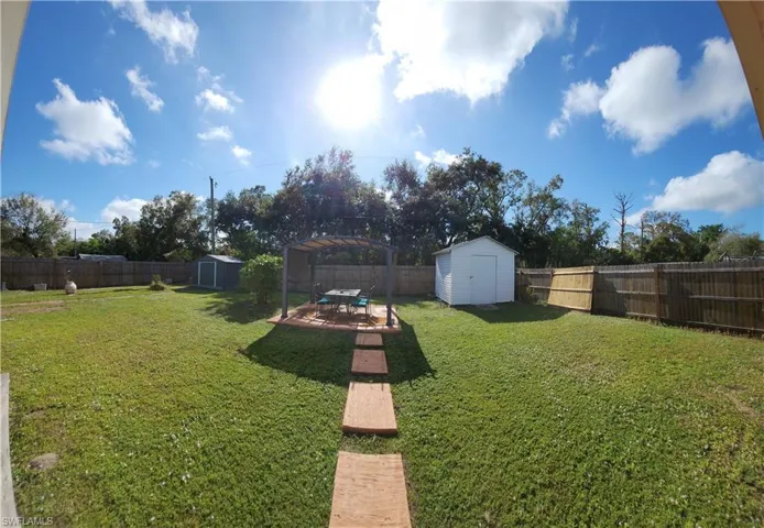 View of huge fenced backyard featuring.