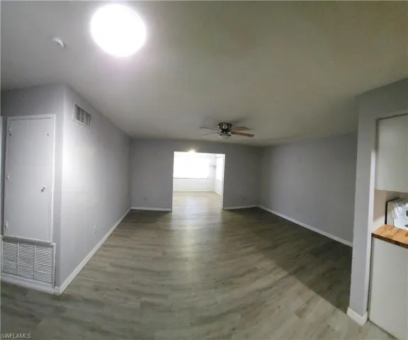 Unfurnished living room with wood-type flooring and ceiling fan