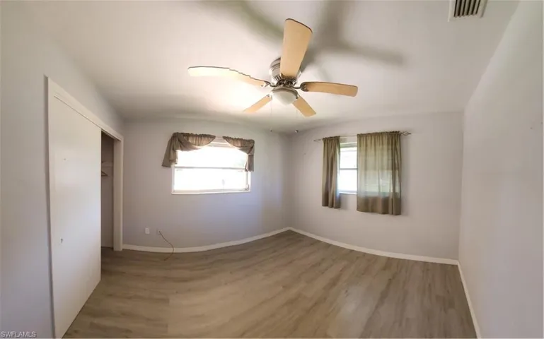 Unfurnished bedroom with a closet, ceiling fan, and hardwood / wood-style flooring