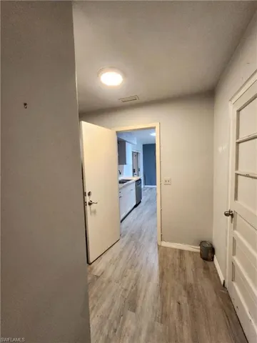 Corridor featuring sink and light wood-type flooring