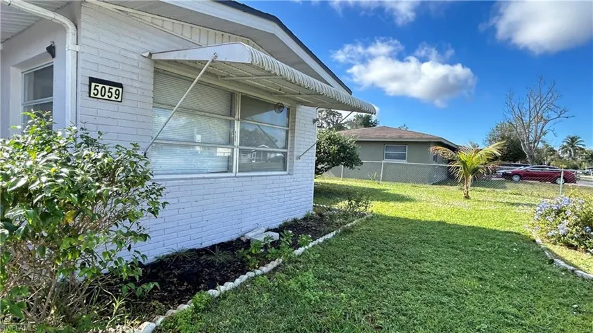 View of side of property featuring a lawn