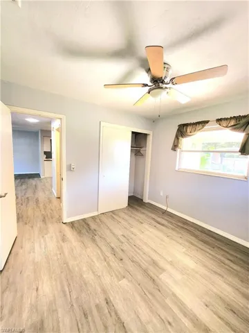 Unfurnished bedroom featuring ceiling fan, a closet, and light hardwood / wood-style flooring