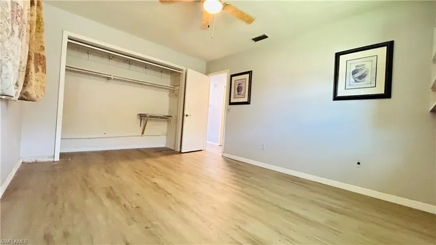 Unfurnished bedroom with light wood-type flooring, a closet, and ceiling fan
