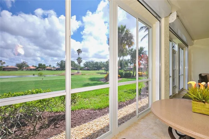 Sunroom with tile patterned floors and a water view