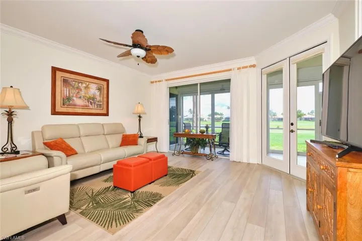 Living area featuring ornamental molding, light wood-style flooring, a ceiling fan, and french doors