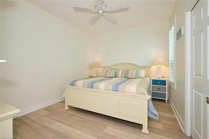 Bedroom featuring light wood finished floors, baseboards, and ceiling fan