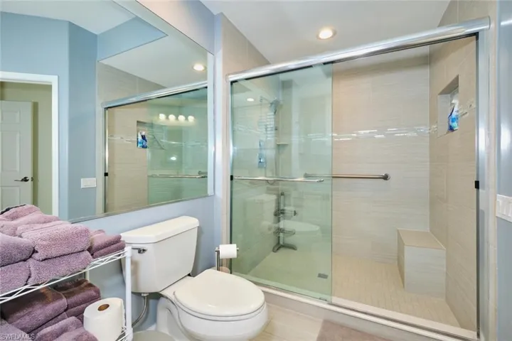 Bathroom featuring toilet, a stall shower, and recessed lighting