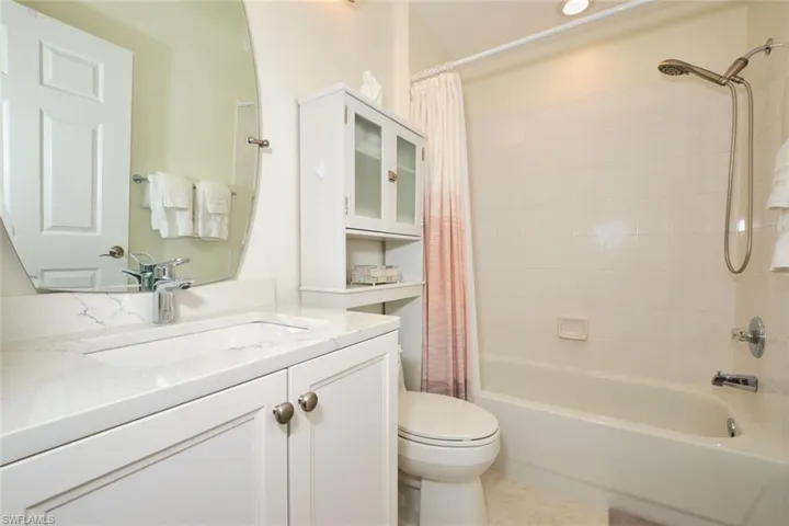 Full bath featuring shower / bath combination with curtain, toilet, and vanity