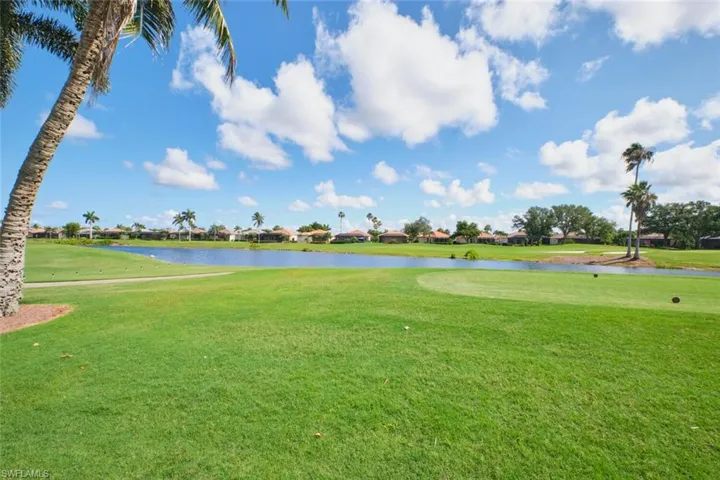 View of property's community featuring a water view, a yard, and golf course view