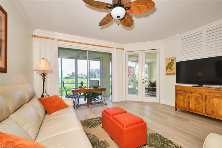 Living room featuring ornamental molding, wood finished floors, french doors, and a ceiling fan