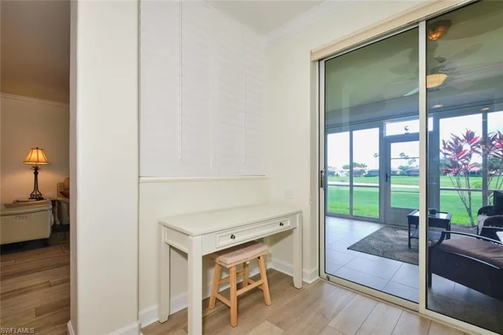 Doorway to outside featuring ornamental molding, light wood-type flooring, baseboards, and a ceiling fan