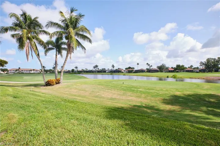 View of green lawn featuring a water view and view of golf course