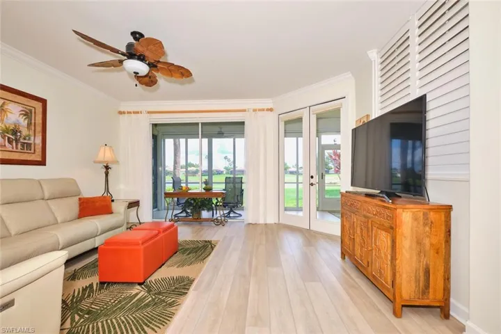 Living area with french doors, crown molding, light wood finished floors, and a ceiling fan