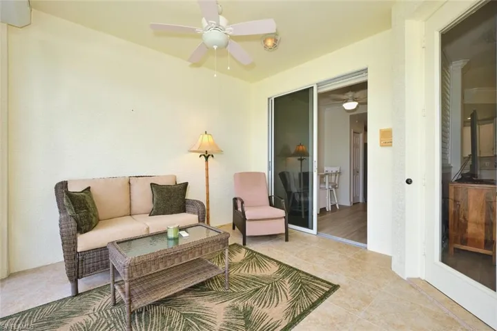 Living area with ceiling fan and light tile patterned floors