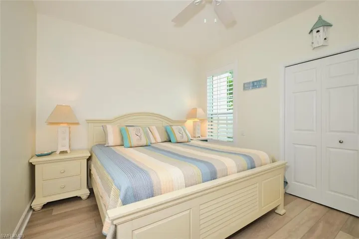 Bedroom featuring light wood-style flooring, a closet, a ceiling fan, and baseboards