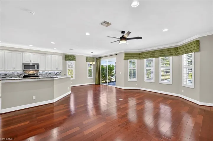 Unfurnished living room featuring ornamental molding, dark wood-style floors, recessed lighting, and ceiling fan