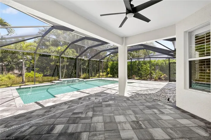 Outdoor pool with a patio, a sunroom, glass enclosure, and ceiling fan