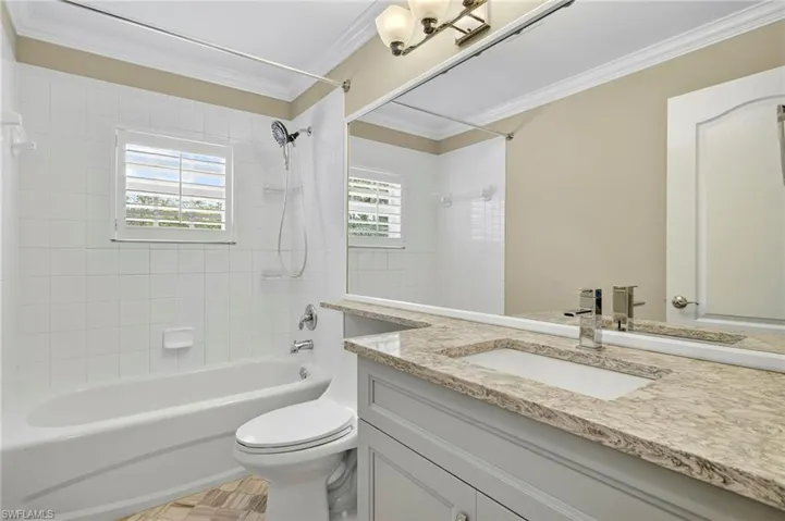 Full bathroom with  shower combination, ornamental molding, plenty of natural light, and vanity