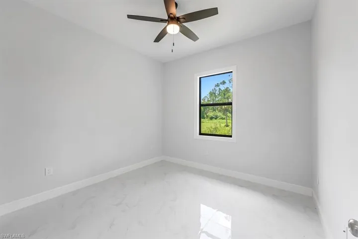 Spare room with light tile patterned flooring and ceiling fan