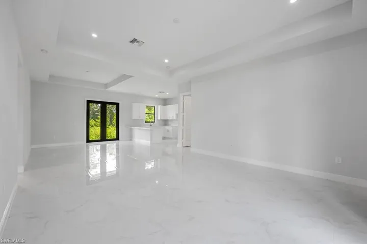 Tiled spare room featuring a tray ceiling