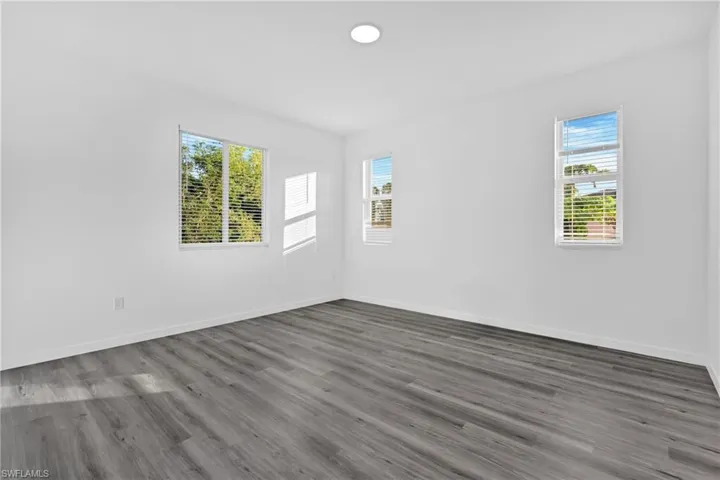 Unfurnished room featuring wood finished floors and plenty of natural light