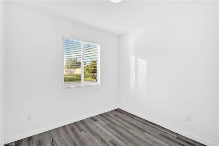 Unfurnished room featuring wood finished floors and baseboards