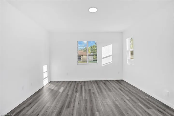 Empty room featuring healthy amount of natural light and wood finished floors