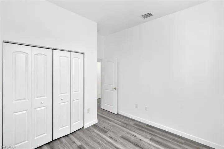 Unfurnished bedroom with a closet and wood finished floors
