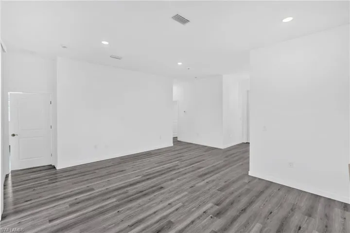 Empty room with light wood-type flooring and recessed lighting