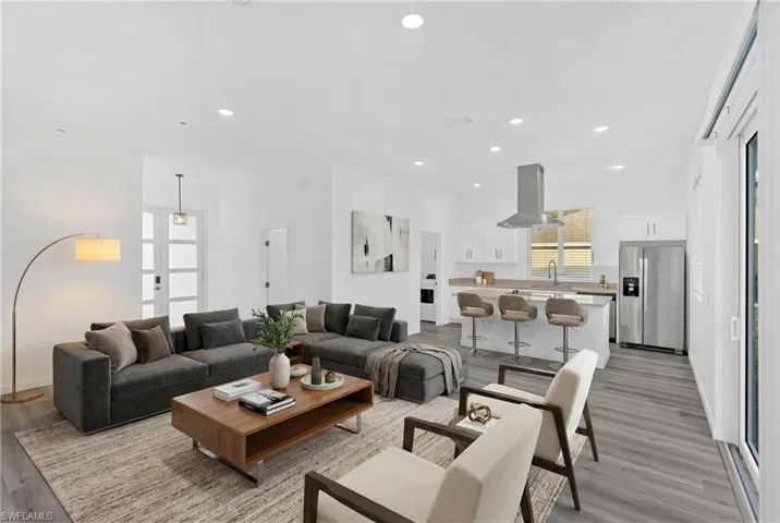 Living room with light wood-type flooring and recessed lighting