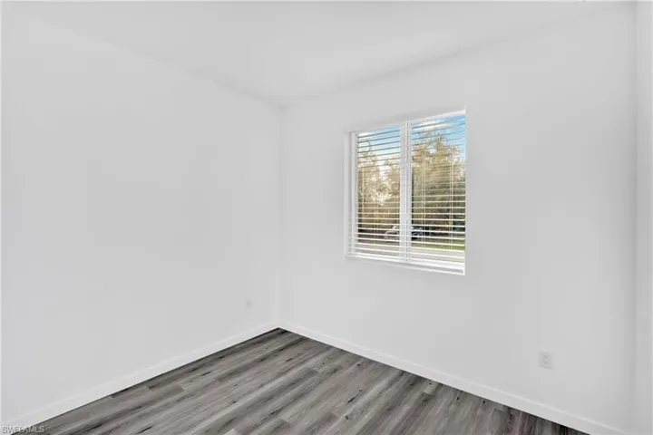 Empty room featuring baseboards and wood finished floors