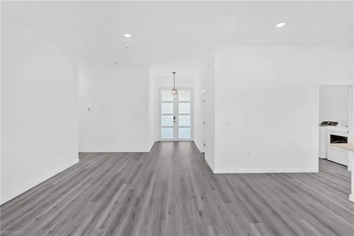 Unfurnished living room featuring recessed lighting, light wood-style floors, washer and clothes dryer, and french doors