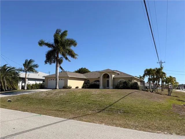 Ranch-style house with a garage, a front yard, concrete driveway, and stucco siding