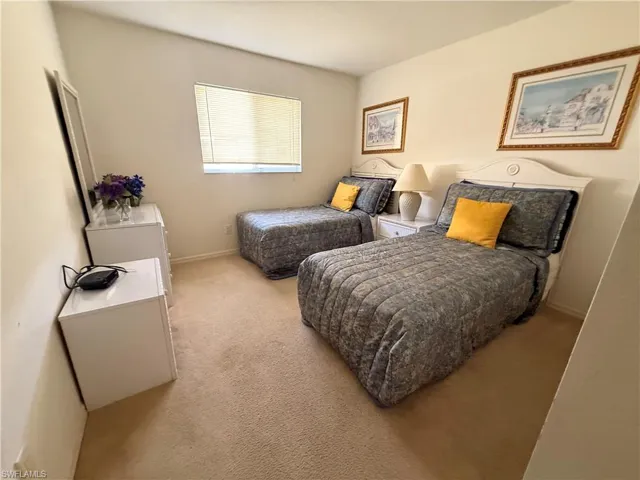 Bedroom featuring light carpet and baseboards
