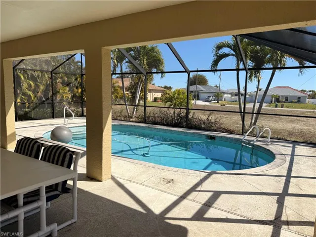Outdoor pool with a sunroom, a patio, a lanai, and a residential view