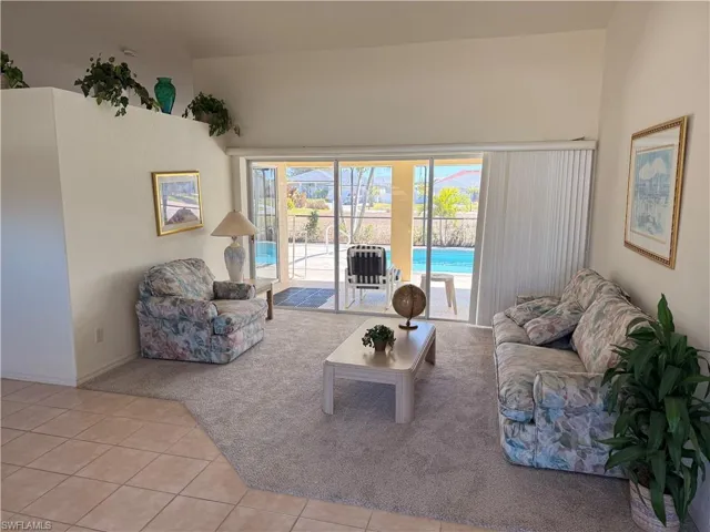 Living area with light tile patterned floors and light carpet