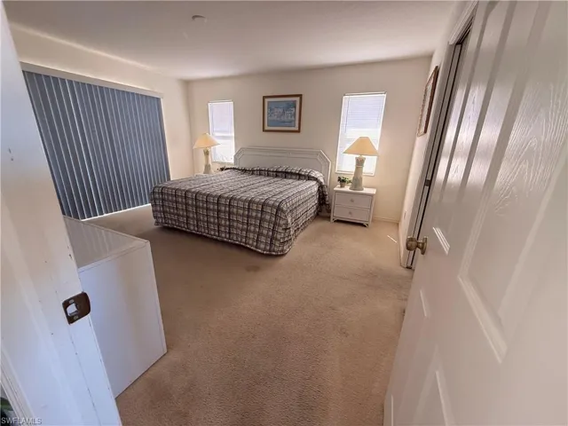 Carpeted bedroom featuring multiple windows