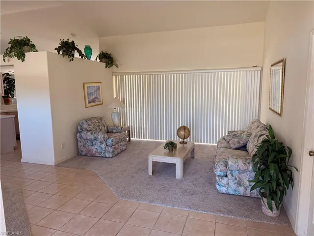 Living room featuring light tile patterned flooring and light colored carpet