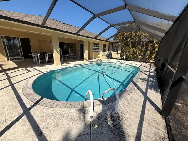 Outdoor pool with a patio area, a sunroom, and a lanai