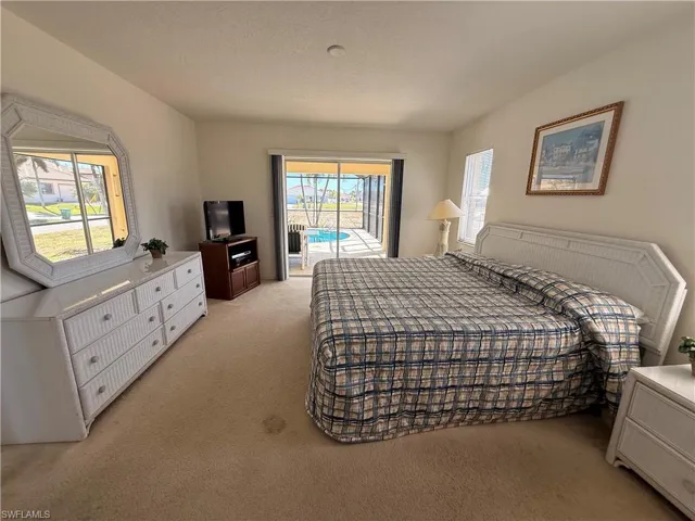 Bedroom featuring access to exterior and light carpet