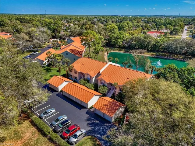 Drone / aerial view of a nearby body of water and a tree filled landscape