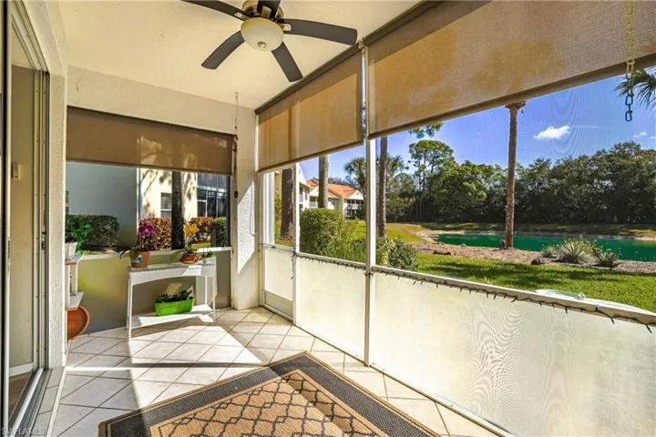 Unfurnished sunroom with a ceiling fan and a water view