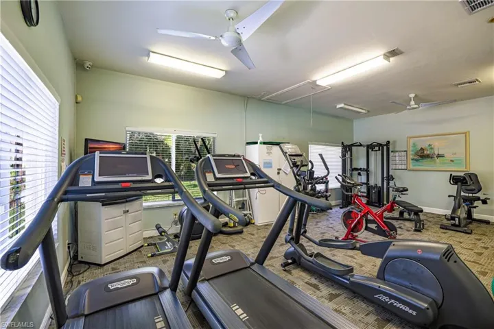 Workout area with ceiling fan and attic access