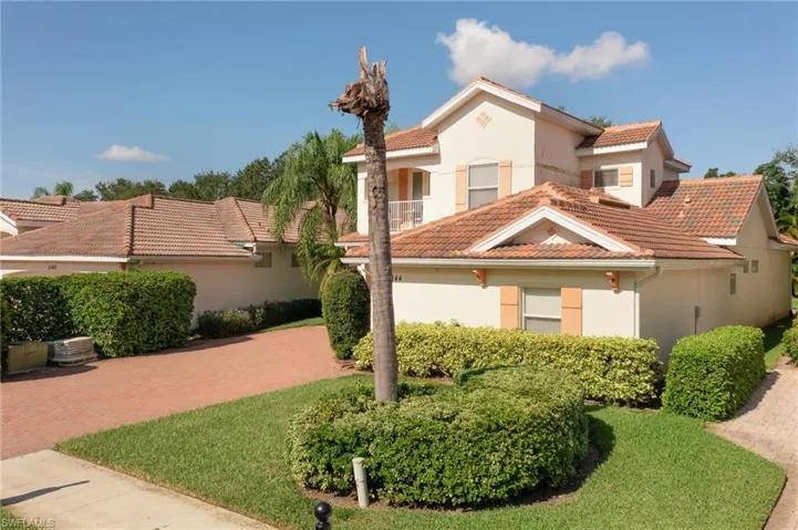 Mediterranean / spanish house featuring a tile roof, stucco siding, and a front lawn
