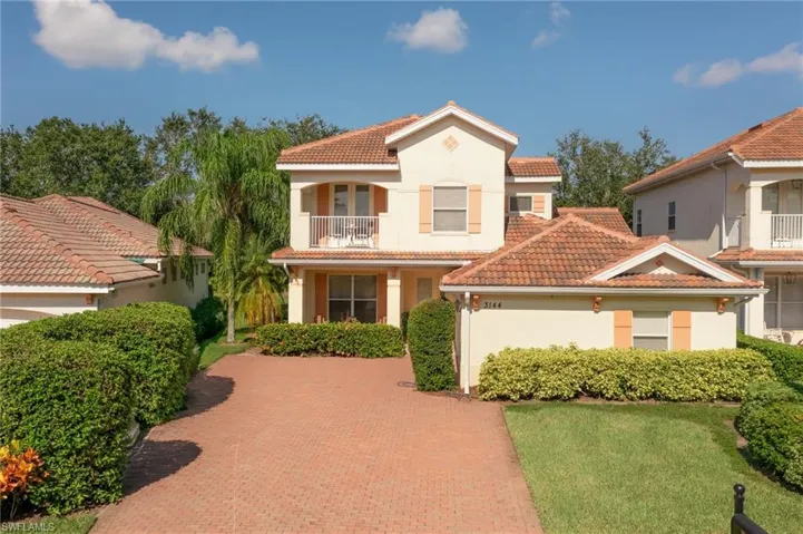 Mediterranean / spanish house with a tile roof, stucco siding, a balcony, and a front yard